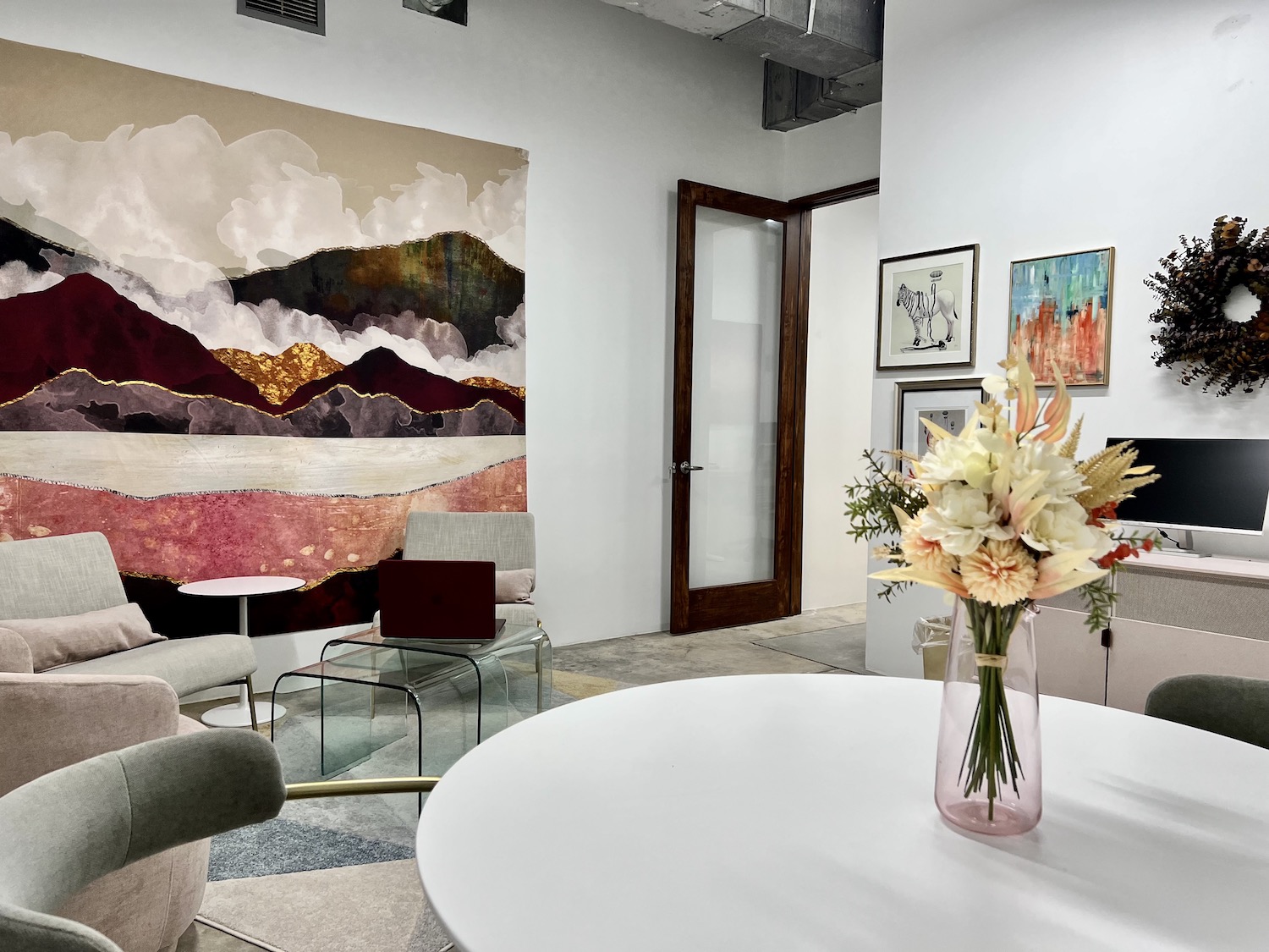 Office Share space of white bistro table, soft lounge seating and lots of art. An inspiring affordable space located at Sesh Coworking in Houston, Texas